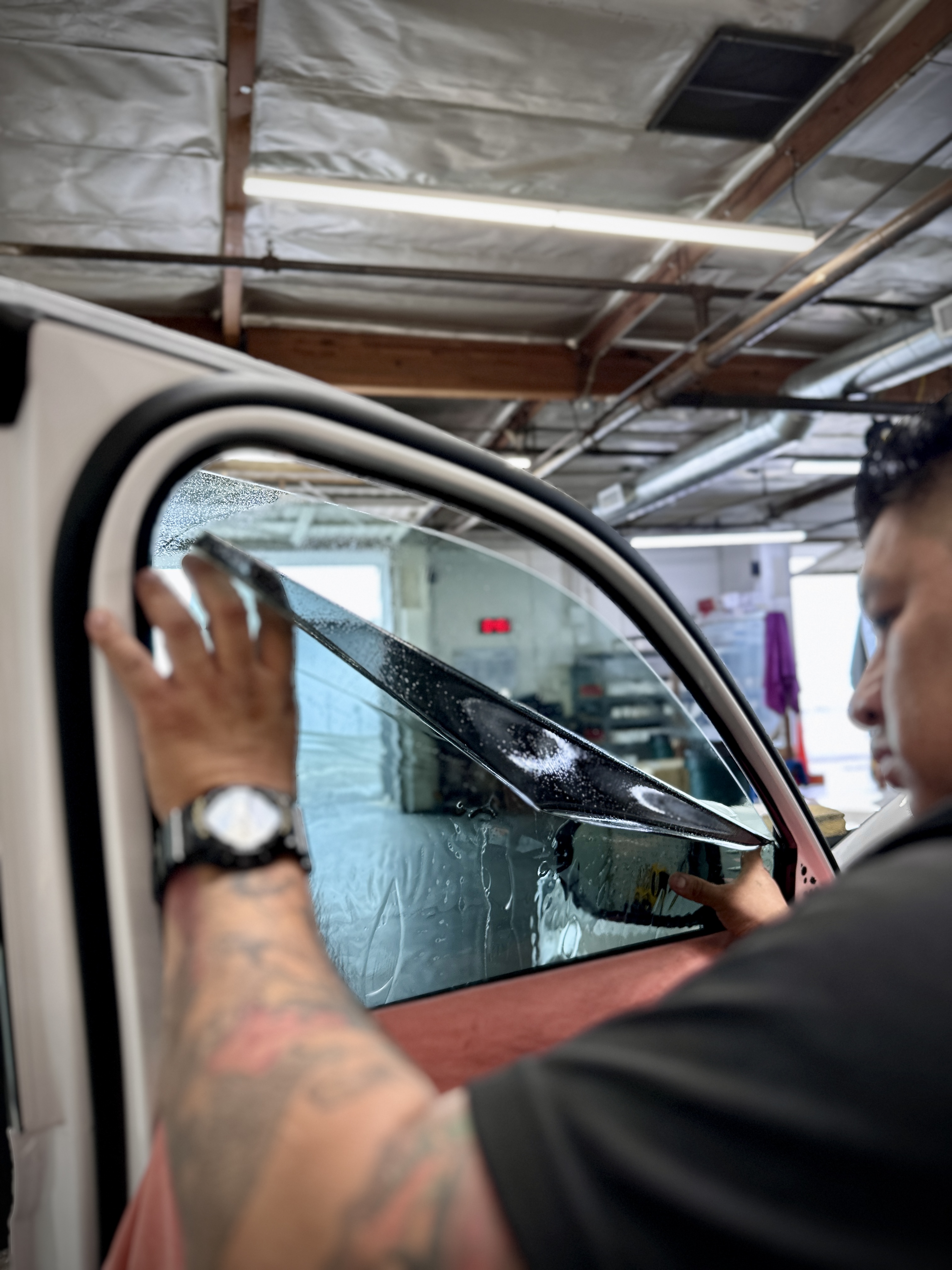 Tint Crew technician applying film to a front door window